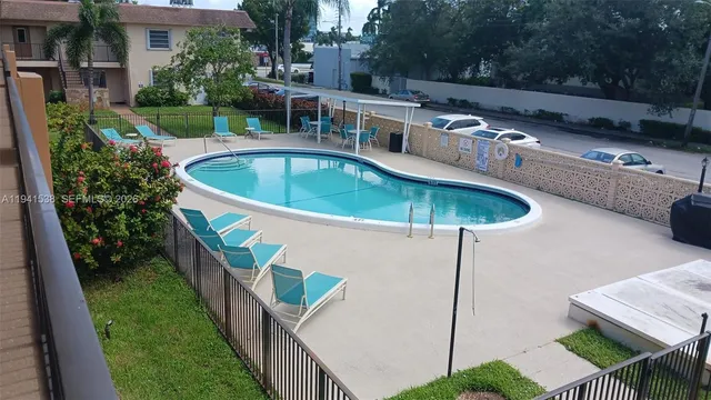 a view of a swimming pool with a patio and a yard