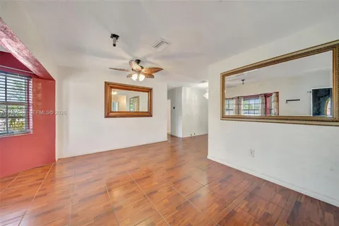 a view of a big room with wooden floor and windows