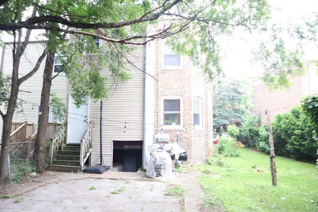 a view of a house with a yard and tree