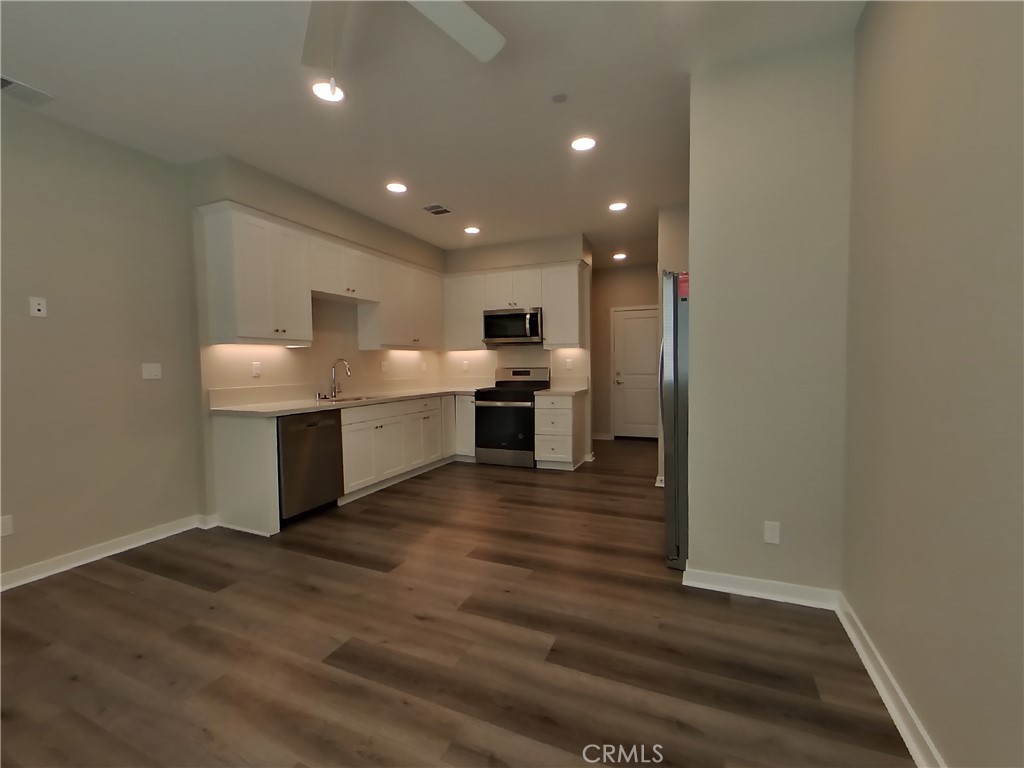 24935 Vermijo Court Wildomar, CA 92595 - Photo 4 of 26 a open kitchen with a sink and dishwasher a refrigerator with wooden floor