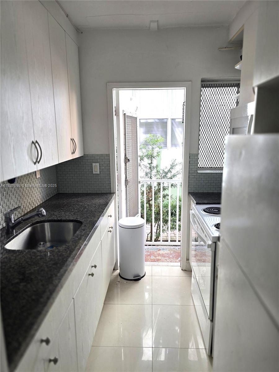 835 Meridian Avenue, Unit 4 Miami Beach, FL 33139 - Photo 11 of 12 a kitchen with a sink and a stove top oven