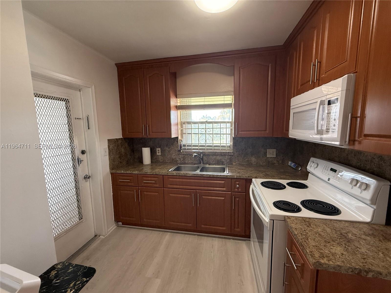 5300 Washington Street, Unit B329 Hollywood, FL 33021 - Photo 4 of 20 a kitchen with stainless steel appliances granite countertop a stove a sink and a microwave