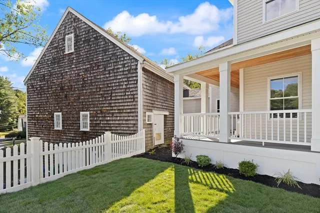 a view of a house with wooden fence and a yard