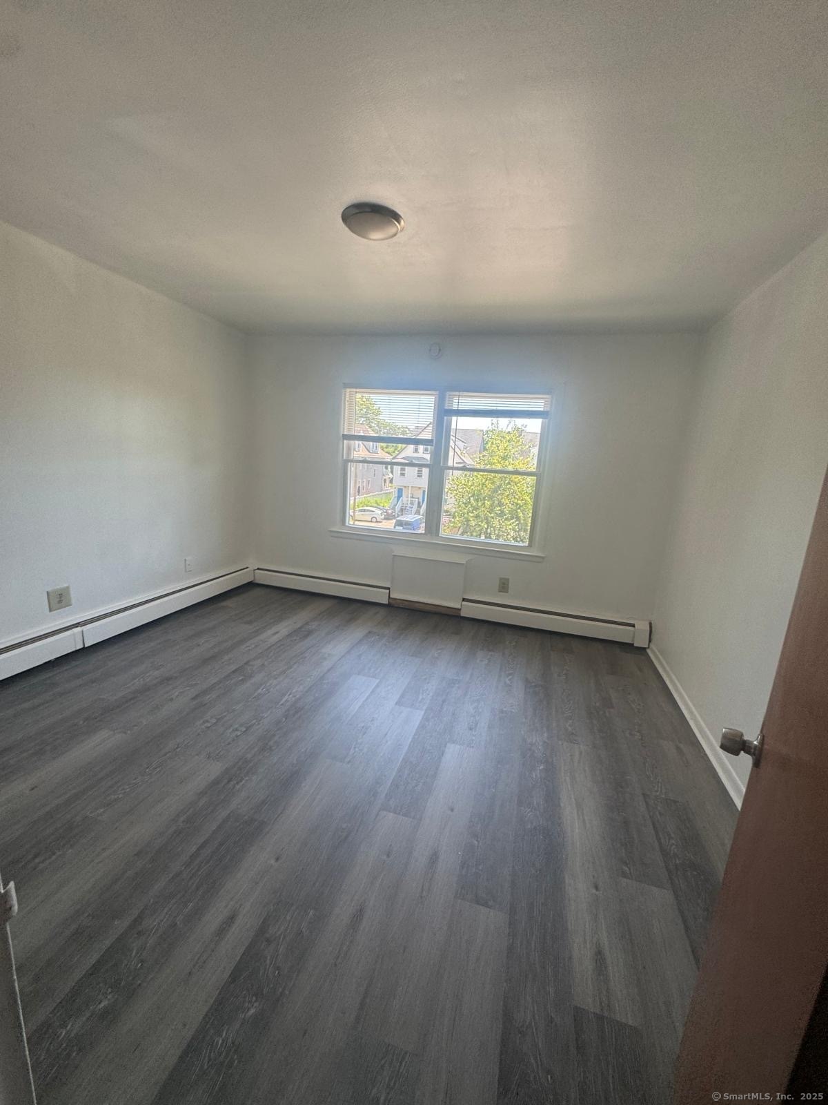 169 Birdseye Street, Unit C2 Bridgeport, CT 06604 - Photo 4 of 10 an empty room with wooden floor and windows