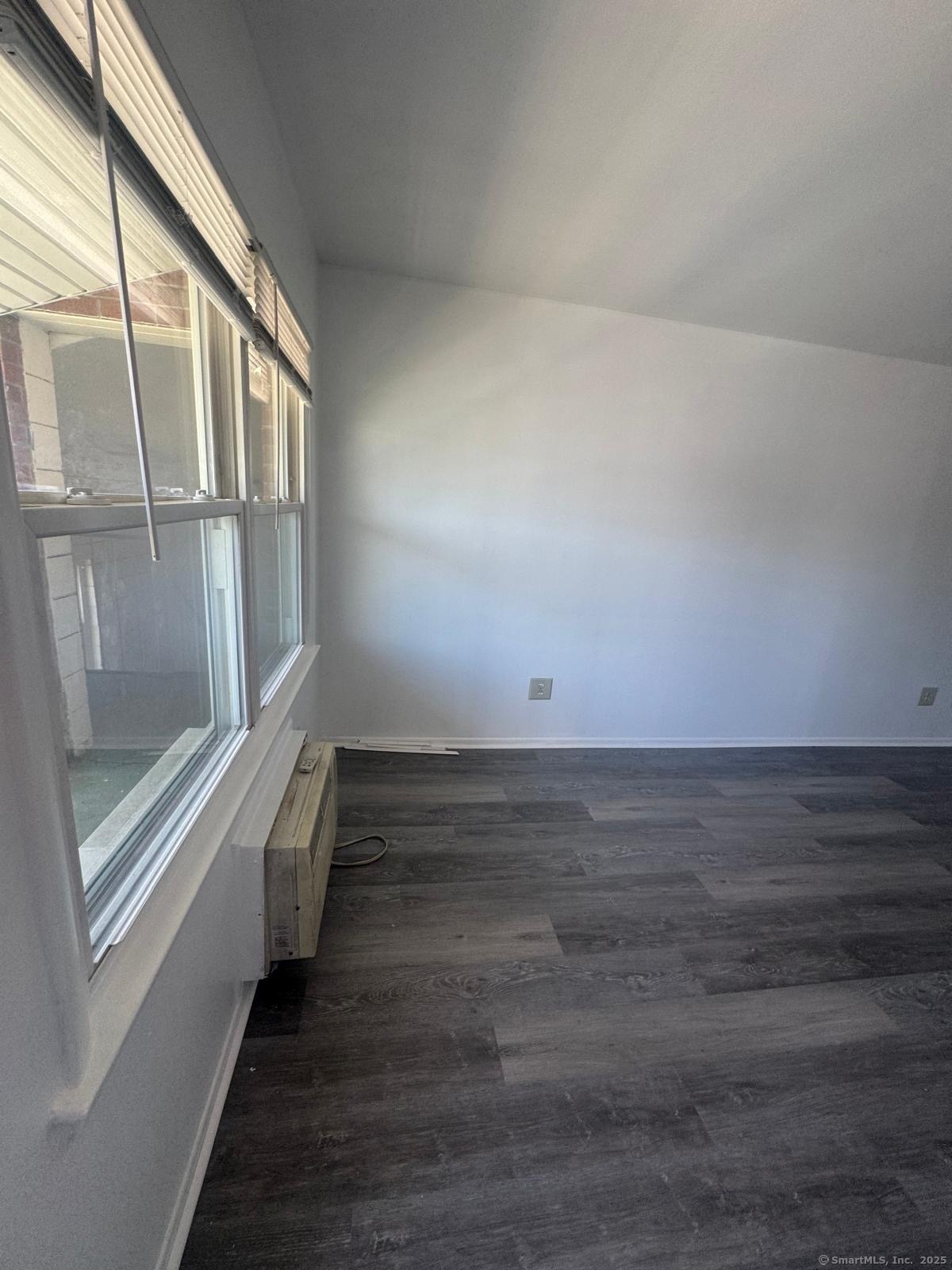 169 Birdseye Street, Unit C2 Bridgeport, CT 06604 - Photo 7 of 10 a view of an empty room with wooden floor and a window