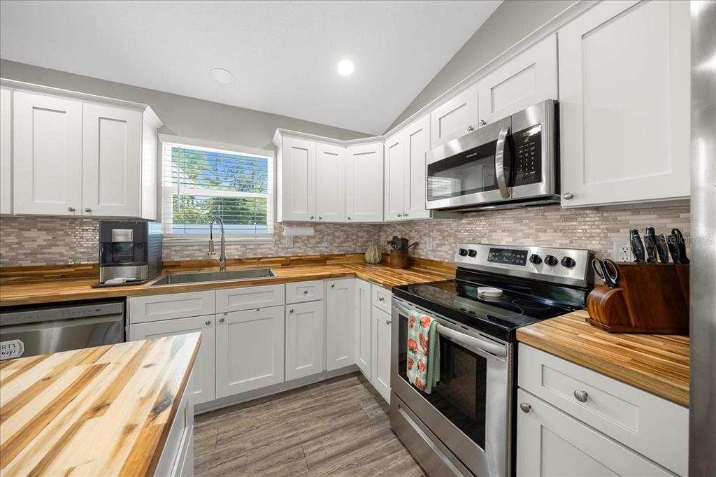 13 Teak Loop Place Ocala, FL 34472 - Photo 22 of 36 a kitchen with stainless steel appliances granite countertop a stove a sink and a microwave