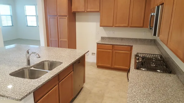 a kitchen with granite countertop a sink stove and cabinets
