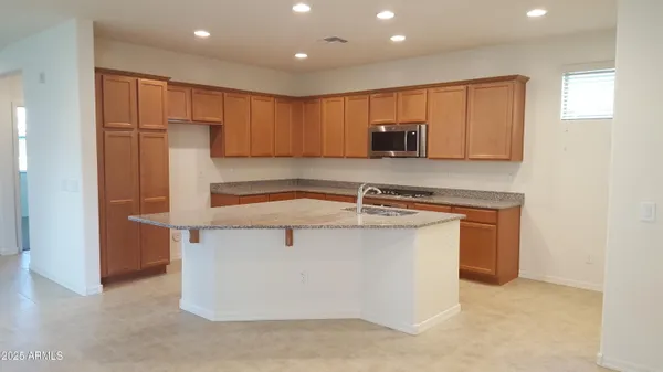 a kitchen with stainless steel appliances granite countertop a sink and a refrigerator
