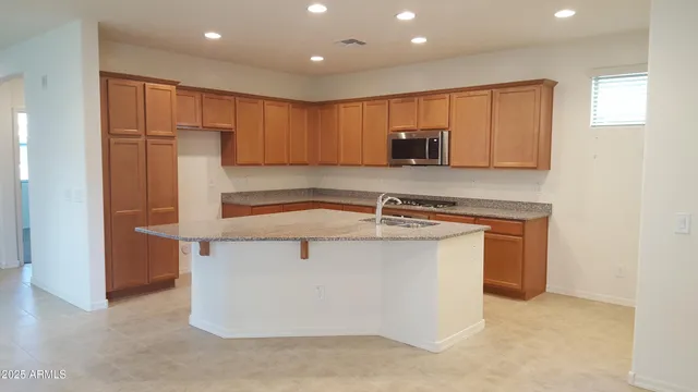 a kitchen with stainless steel appliances granite countertop a sink and a refrigerator