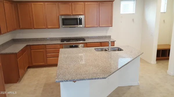 a kitchen with stainless steel appliances granite countertop a sink a stove and a microwave
