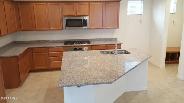 a kitchen with stainless steel appliances granite countertop a sink a stove and a microwave