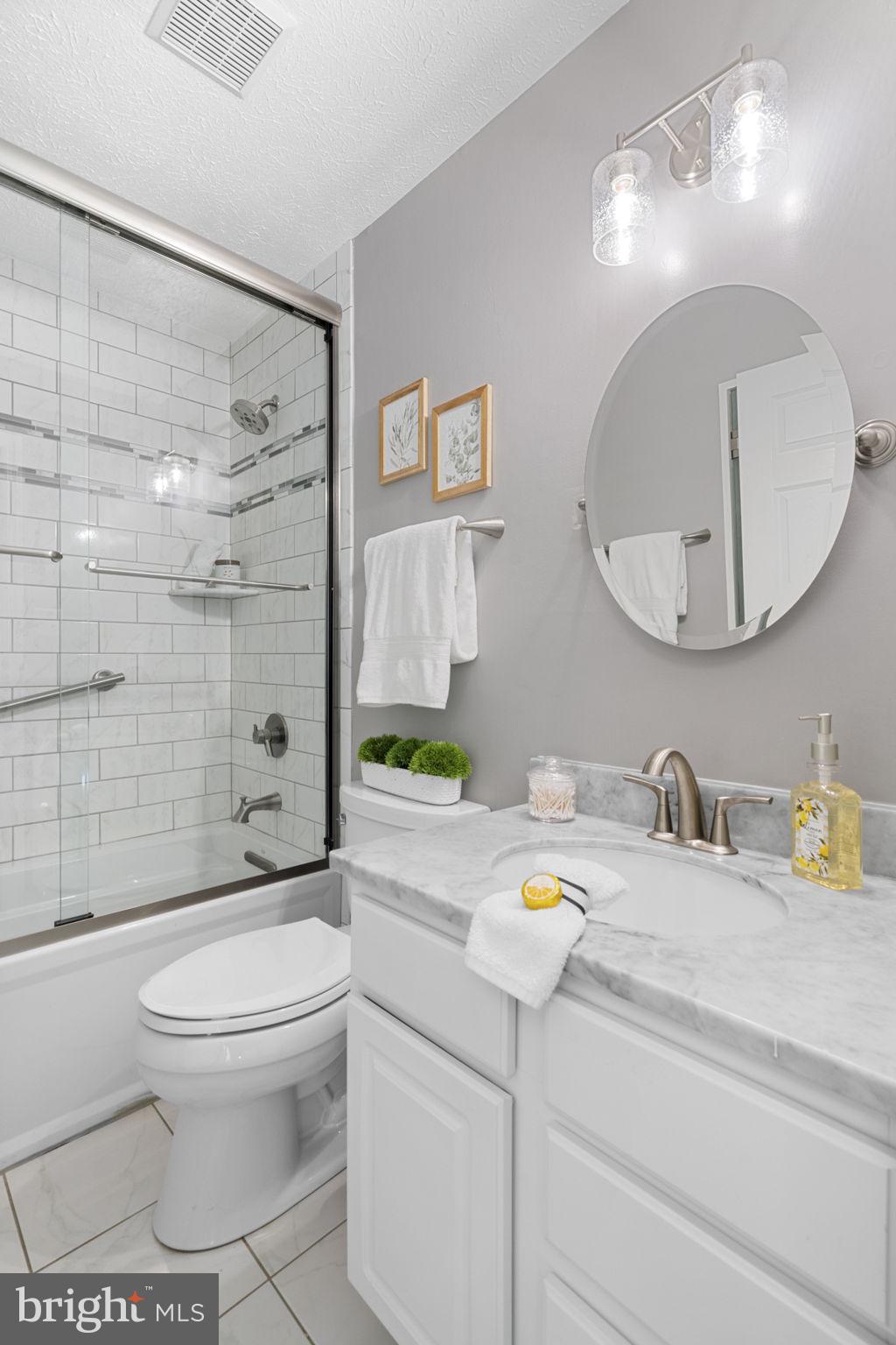 18607 Cabin Road Triangle, VA 22172 - Photo 30 of 64 a bathroom with a granite countertop toilet sink and mirror