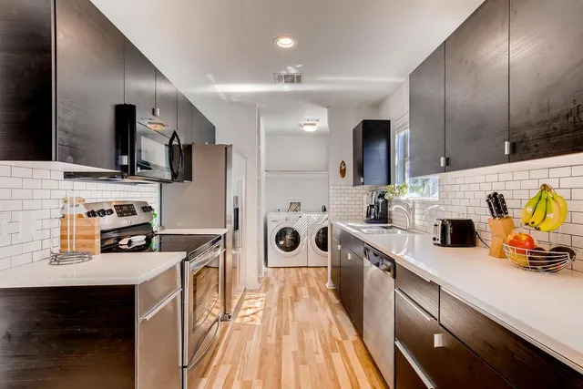 a kitchen with stainless steel appliances a sink stove and refrigerator
