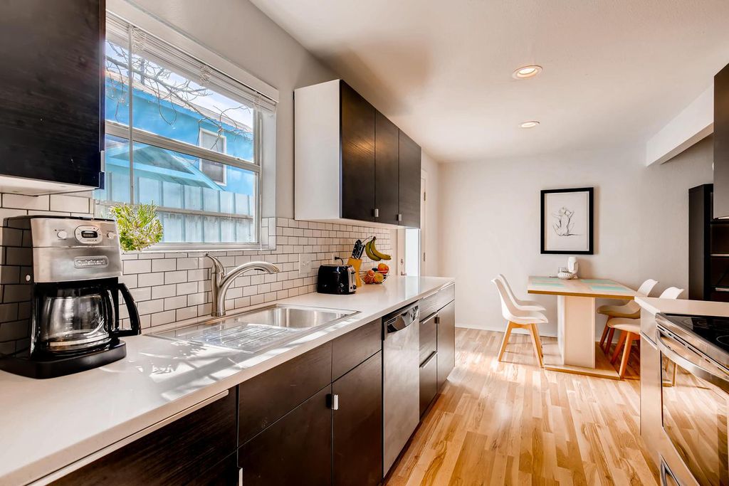 1312 Cometa Street, Unit A Austin, TX 78721 - Photo 3 of 18 Kitchen featuring decorative backsplash, light countertops, light wood finished floors, recessed lighting, and appliances with stainless steel finishes