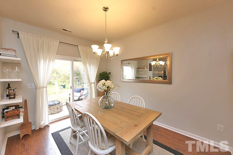 5121 Echo Ridge Road Raleigh, NC 27612 - Photo 5 of 16 a view of a dining room with furniture a chandelier and wooden floor