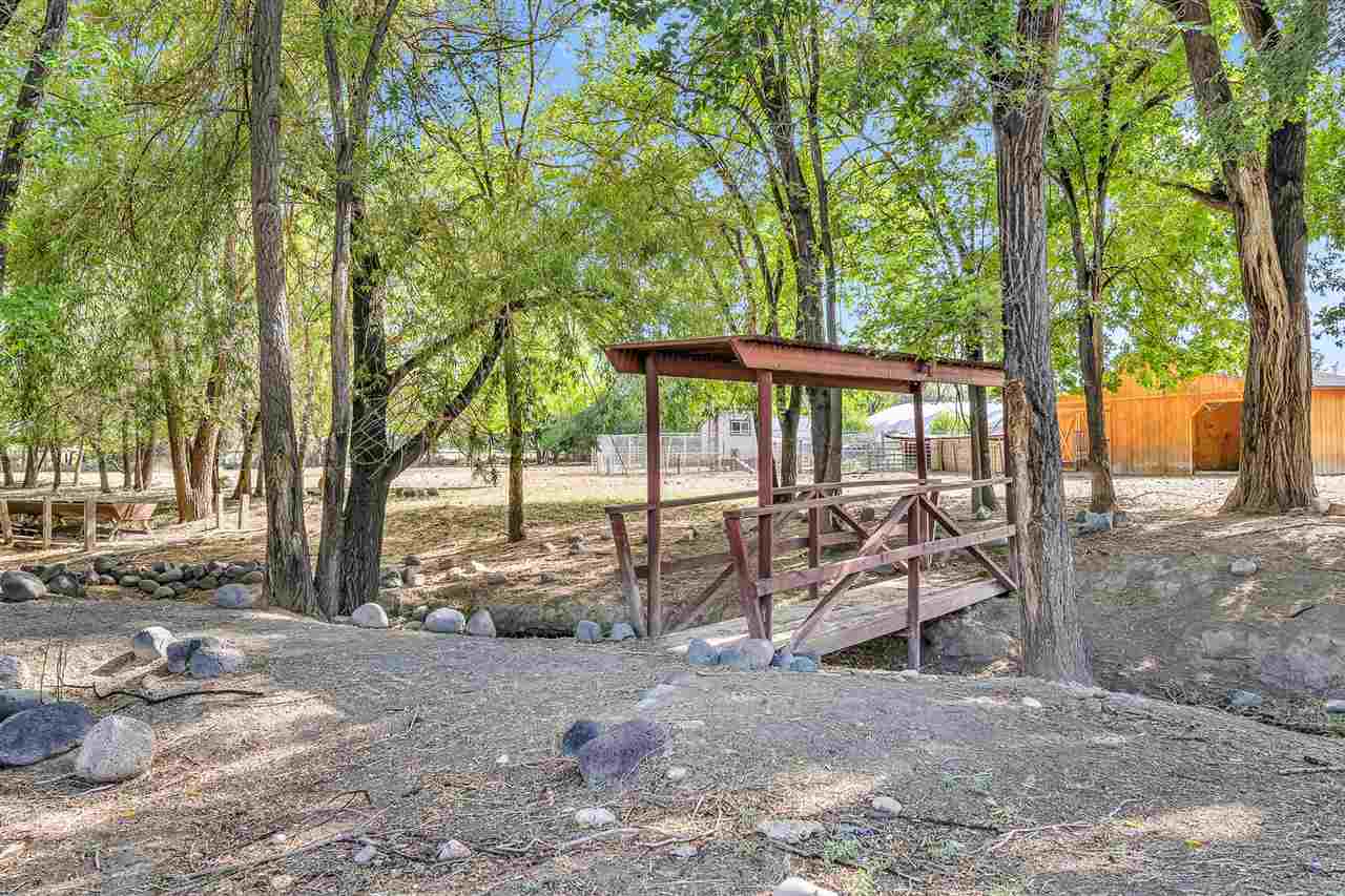 3301 F Road Clifton, CO 81520 - Photo 36 of 42 a view of a patio with table and chairs under an umbrella with large trees