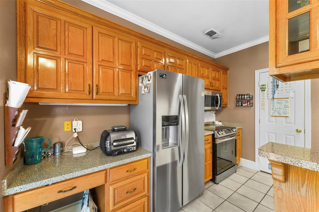 301 Elm Street Quinlan, TX 75474 - Photo 13 of 40 a kitchen with stainless steel appliances granite countertop a refrigerator and a sink