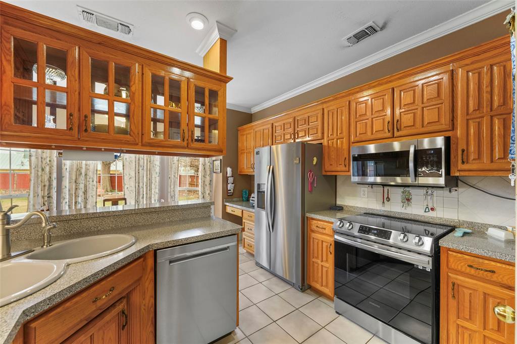 301 Elm Street Quinlan, TX 75474 - Photo 16 of 40 a kitchen with stainless steel appliances granite countertop a stove and a refrigerator