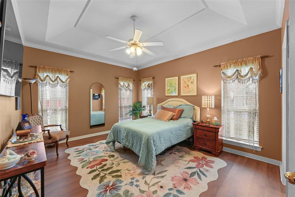 301 Elm Street Quinlan, TX 75474 - Photo 17 of 40 a bedroom with a bed and wooden floor