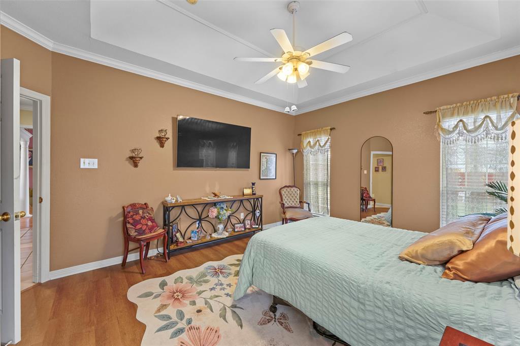 301 Elm Street Quinlan, TX 75474 - Photo 18 of 40 a bedroom with a bed and a flat screen tv