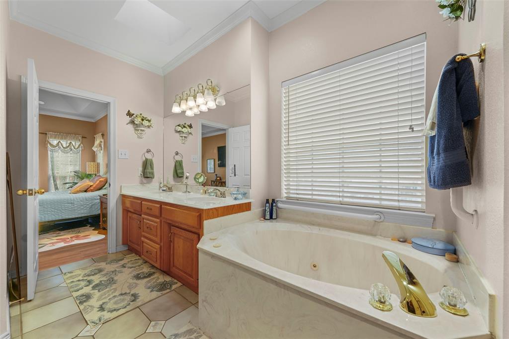 301 Elm Street Quinlan, TX 75474 - Photo 22 of 40 a bathroom with a tub sink and mirror