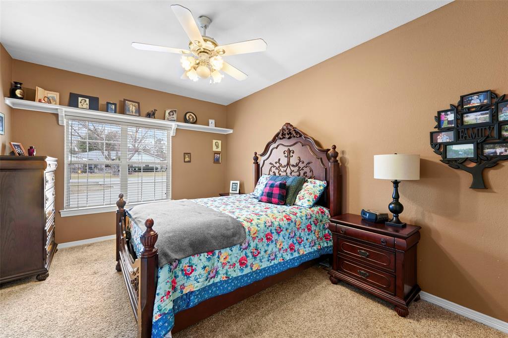 301 Elm Street Quinlan, TX 75474 - Photo 25 of 40 a bedroom with a bed and a chandelier