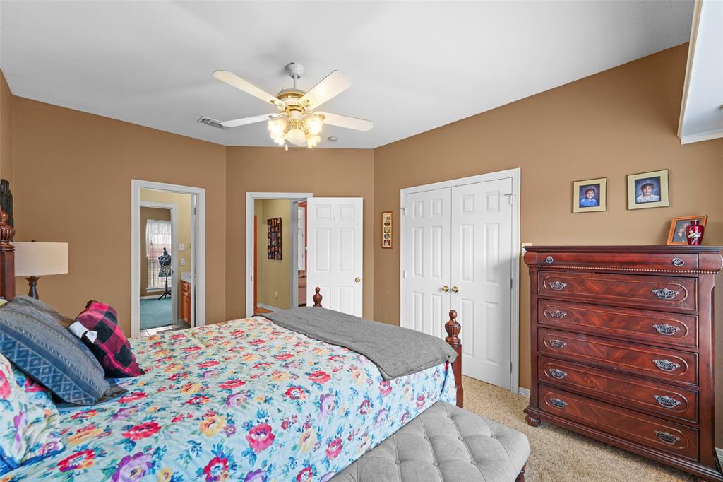 301 Elm Street Quinlan, TX 75474 - Photo 26 of 40 a bedroom with a bed and a chandelier