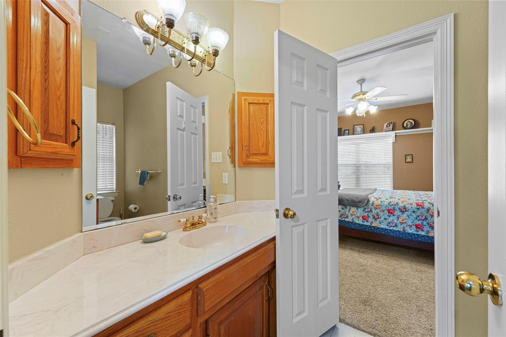 301 Elm Street Quinlan, TX 75474 - Photo 27 of 40 a en suite bathroom with a double vanity sink and a mirror