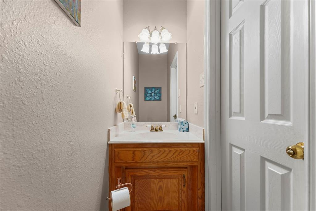 301 Elm Street Quinlan, TX 75474 - Photo 30 of 40 a bathroom with a sink and a mirror