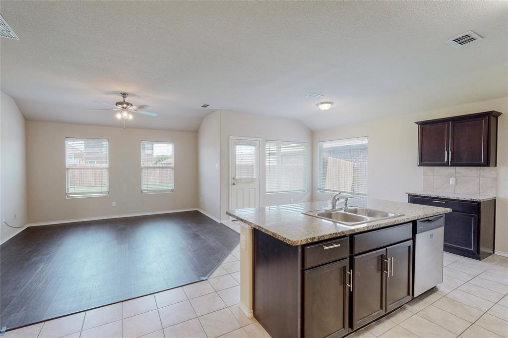 a kitchen with stainless steel appliances granite countertop a sink dishwasher and a stove with wooden floor