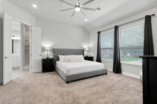 a spacious bedroom with a bed and a chandelier
