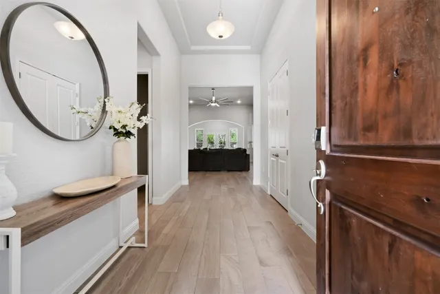a view of a hallway with wooden floor windows and a bathroom