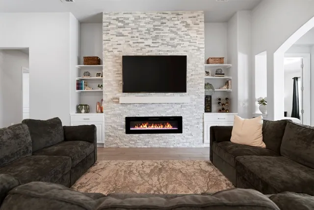 a living room with furniture a flat screen tv and a fireplace