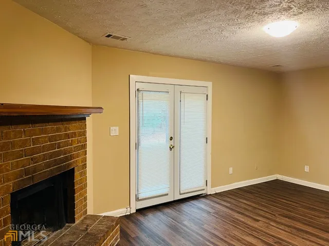 a view of empty room with wooden floor and fireplace