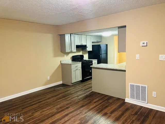 a view of a kitchen with wooden floor and electronic appliances