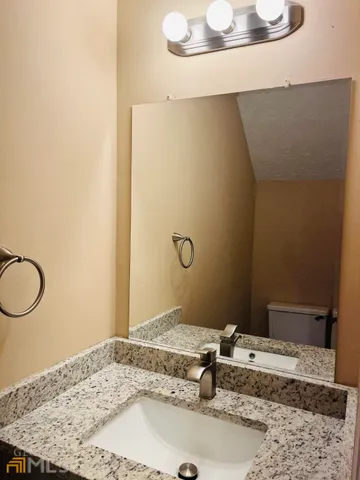 a bathroom with a granite countertop sink and a mirror
