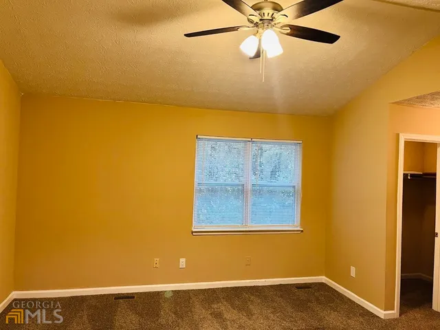 a view of a room with a window and ceiling fan