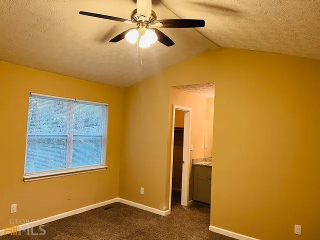 a view of a room with a ceiling fan and a window