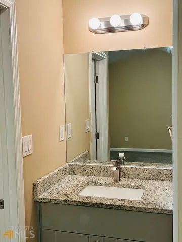 a bathroom with a granite countertop sink and a mirror