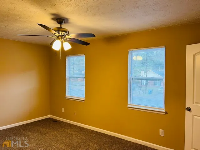 a view of a room with a ceiling fan and a window