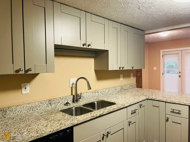 a kitchen with granite countertop a sink and cabinets
