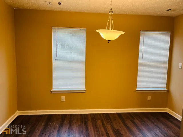 a view of a room with wooden floor and a window