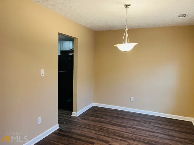 a view of a room with wooden floor and ceiling fan