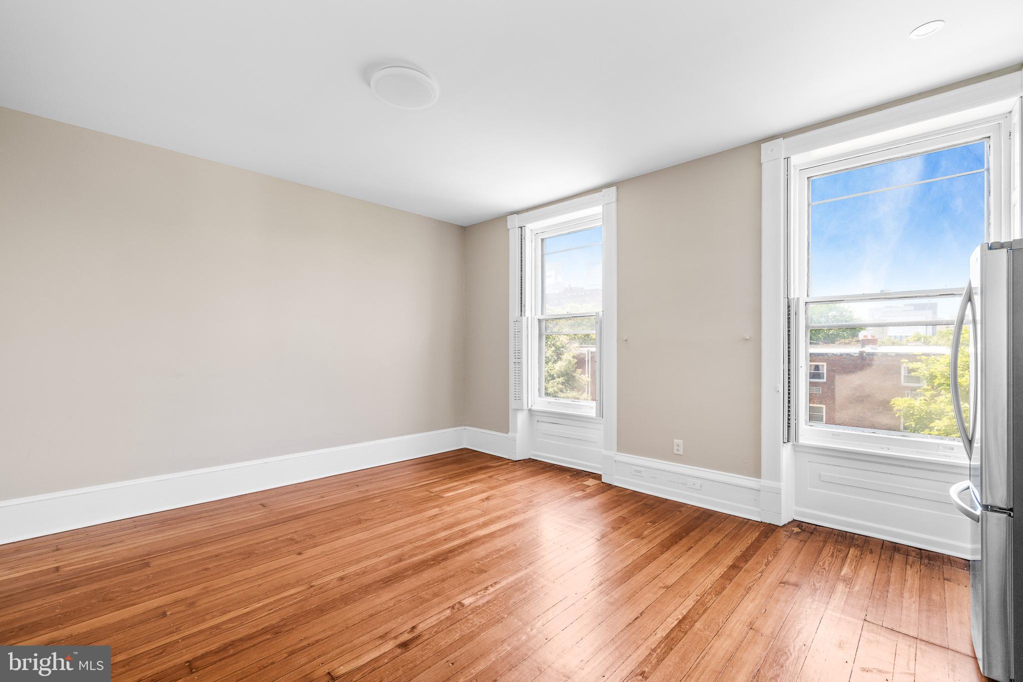 2311 Green Street, Unit 2F Philadelphia, PA 19130 - Photo 4 of 13 an empty room with wooden floor and windows