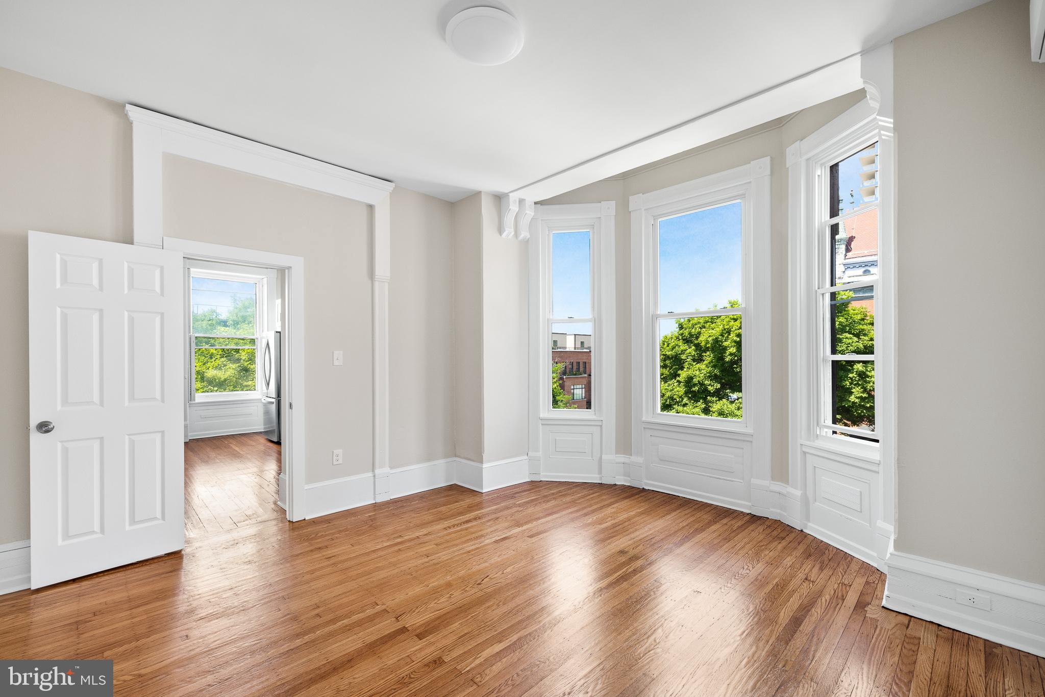 2311 Green Street, Unit 2F Philadelphia, PA 19130 - Photo 7 of 13 an empty room with wooden floor and windows