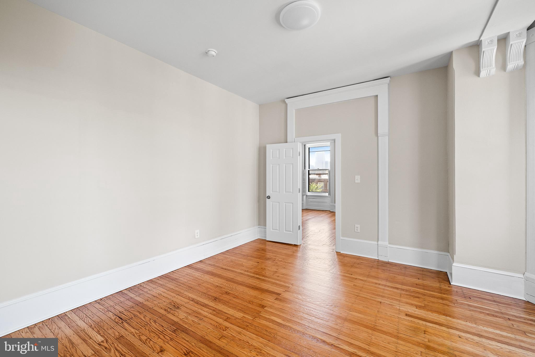 2311 Green Street, Unit 2F Philadelphia, PA 19130 - Photo 9 of 13 a view of an empty room with wooden floor and a window