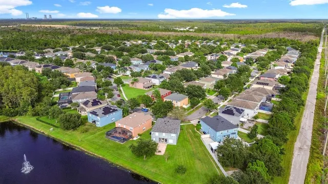 an aerial view of residential houses with outdoor space and trees