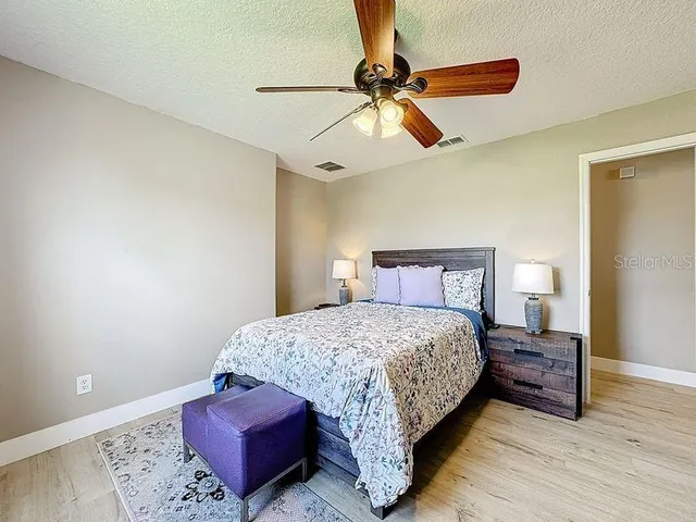 a spacious bedroom with a bed and a chandelier