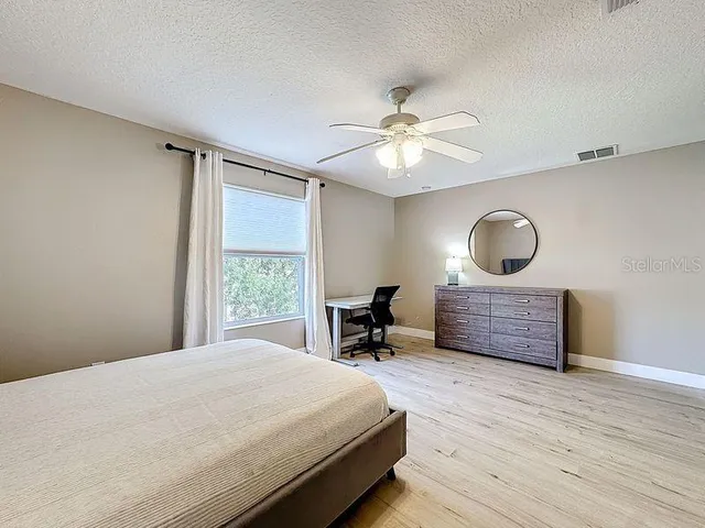 a bedroom with a bed and wooden floor