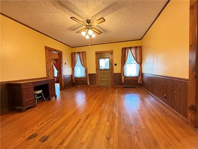 a view of empty room with window and wooden floor